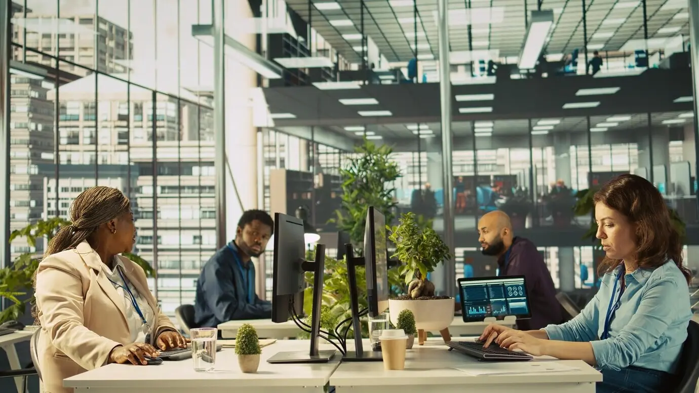 Бухгалтер в оживлённом современном стартап-агентстве вводит финансовые показатели на ПК.